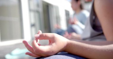 Güneşli bir günde terasta yoga yapan melez anne ve kız çocuklarınız kutlu olsun. Ağır çekimde. Aile, annelik, fitness, yoga, refah, çocukluk ve birliktelik.