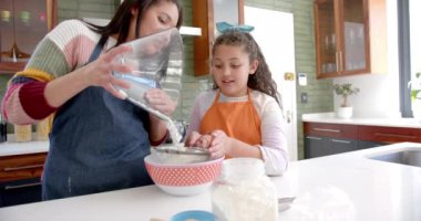 Mutlu çift ırklı anne ve kız güneşli mutfakta hamur hazırlıyor. Yemek, pişirme, aile, annelik, çocukluk, aşk, birliktelik ve aile hayatı, değişmemiş.