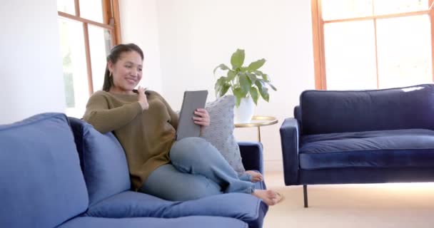 Heureuse Femme Biraciale Assise Sur Canapé Souriante Utilisant Une Tablette — Video
