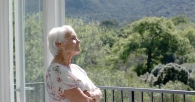 Balkonda durup kucaklaşan, ağır çekimde mutlu Kafkasyalı çift. Kıdemli yaşam tarzı, birliktelik ve aile hayatı, değişmedi..