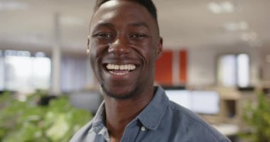 Sıradan bir Afro-Amerikan iş adamının portresi ofiste gülümsüyor, fotokopi aletiyle ağır çekimde. Günlük iş, iş, ofis ve bağlantı konsepti, değiştirilmemiş.