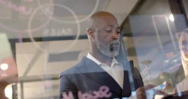 Ofisteki cam duvara fotokopi alanı ile yazı yazan Afrikalı Amerikalı iş adamı. İş, iş, ofis, profesyonel konsept, değiştirilmemiş.