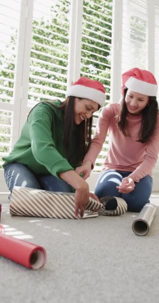 Vídeo Vertical Feliz Madre Hija Birracial Sombreros Navidad Envolviendo Regalo — Vídeo de stock