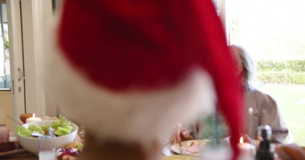 友人とクリスマスのディナーテーブルで抱擁するハッピーな多様なシニアカップル スローモーション クリスマス お祝い そしてシニアライフスタイル 変わらない — ストック動画