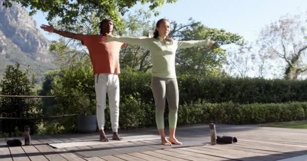 晴れた庭に立ってヨガを練習するハッピー多様なカップル スペースをコピー スローモーション ウェルビーイング フィットネス トグルネス 健康的なライフスタイル 変わらない — ストック動画