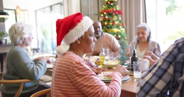 クリスマスディナーのテーブルにいる アフリカ系アメリカ人女性で 友達がたくさんいる スローモーション クリスマス お祝い そしてシニアライフスタイル 変わらない — ストック動画