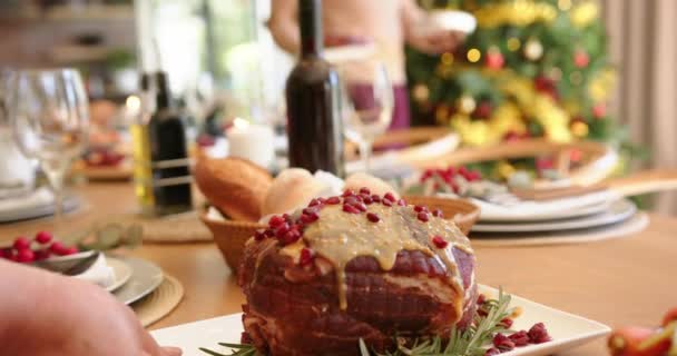 クリスマスのダイニングテーブルに料理を置くハッピーな多様なシニア男性と女性の友人 スローモーション 食べ物 クリスマス お祝い そしてシニアライフスタイル 変わらない — ストック動画