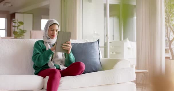 Femme Naissante Dans Hijab Utilisant Une Tablette Sur Canapé Maison — Video