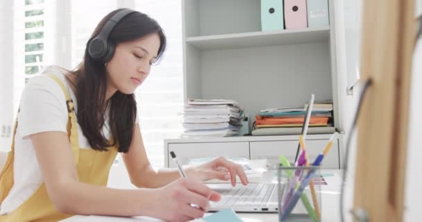 Kulaklıklı Dizüstü Bilgisayarı Kullanan Evde Çalışan Ağır Çekimde Çalışan Melez — Stok video