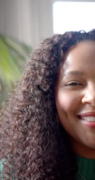 Вертикальний Відео Напівпортрет Щасливої Афроамериканки Кучерявим Волоссям Посміхається Сонячній Кімнаті — стокове відео