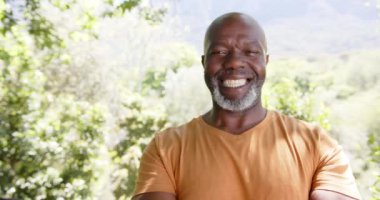 Mutlu, kel, yaşlı, Afro-Amerikan bir adamın portresi. Güneşli doğada gülümsüyor. Kopya alanı, ağır çekim. Yaz, emeklilik, refah ve sağlıklı yaşlı yaşam tarzı, değişmemiş..