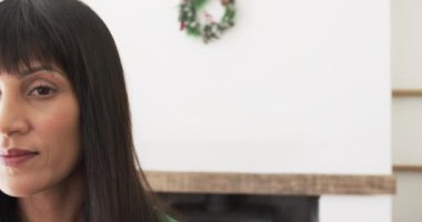 Evde Noel çelengi ile gülümseyen mutlu melez kadın portresi, fotokopi alanı, ağır çekim. Noel, gelenek ve kutlama, değişmeden.