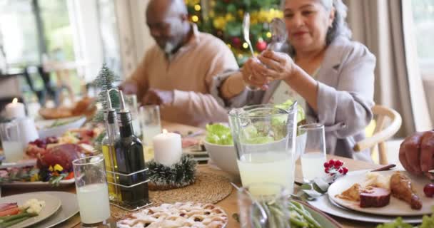 クリスマスディナー スローモーションを食べたり 食べたりする多様なシニア男性と女性の友人 クリスマス お祝い そしてシニアライフスタイル 変わらない — ストック動画
