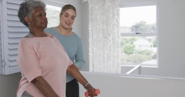 Kafkasyalı kadın fizyoterapist. Egzersiz yapıyor, fotokopi çekiyor, yavaş çekim yapıyor. Yaşlılar yaşam tarzı, fizyoterapist, sağlık hizmetleri, bakım, tıp, meslek, iş konsepti, değiştirilmemiş.