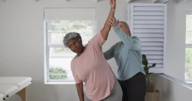 Kafkasyalı kadın fizyoterapist. Egzersiz yapıyor, fotokopi çekiyor, yavaş çekim yapıyor. Yaşlılar yaşam tarzı, fizyoterapist, sağlık hizmetleri, bakım, tıp, meslek, iş konsepti, değiştirilmemiş.