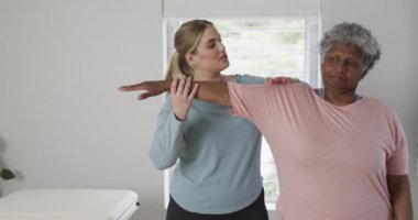 Kafkasyalı kadın fizyoterapist. Egzersiz yapıyor, fotokopi çekiyor, yavaş çekim yapıyor. Yaşlılar yaşam tarzı, fizyoterapist, sağlık hizmetleri, bakım, tıp, meslek, iş konsepti, değiştirilmemiş.