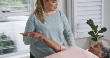 Kafkas kadın fizyoterapist kıdemli kadına masaj yapıyor, kopyalama alanı, yavaş çekim. Yaşlılar yaşam tarzı, fizyoterapist, sağlık hizmetleri, bakım, tıp, meslek, iş konsepti, değiştirilmemiş.