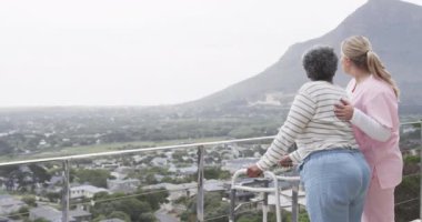 Kafkas kadın hemşire ve yaşlı Afro-Amerikan kadın hasta, ağır çekimde yürüyor. Yaşlılar yaşam tarzı, hemşire, sağlık, bakım, ilaç, meslek, iş kavramı, değiştirilmemiş.