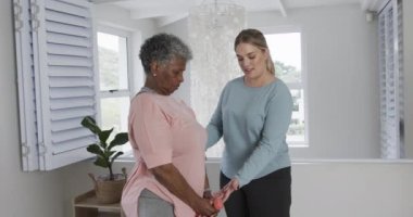 Kafkasyalı kadın fizyoterapist. Egzersiz yapıyor, fotokopi çekiyor, yavaş çekim yapıyor. Yaşlılar yaşam tarzı, fizyoterapist, sağlık hizmetleri, bakım, tıp, meslek, iş konsepti, değiştirilmemiş.