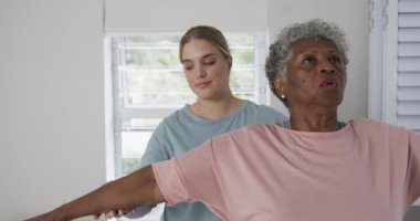 Kafkasyalı kadın fizyoterapist. Egzersiz yapıyor, fotokopi çekiyor, yavaş çekim yapıyor. Yaşlılar yaşam tarzı, fizyoterapist, sağlık hizmetleri, bakım, tıp, meslek, iş konsepti, değiştirilmemiş.