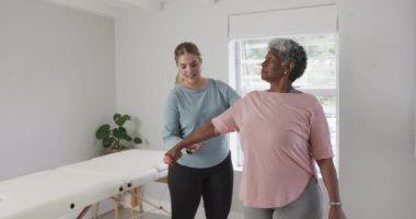 Kafkasyalı kadın fizyoterapist. Egzersiz yapıyor, fotokopi çekiyor, yavaş çekim yapıyor. Yaşlılar yaşam tarzı, fizyoterapist, sağlık hizmetleri, bakım, tıp, meslek, iş konsepti, değiştirilmemiş.