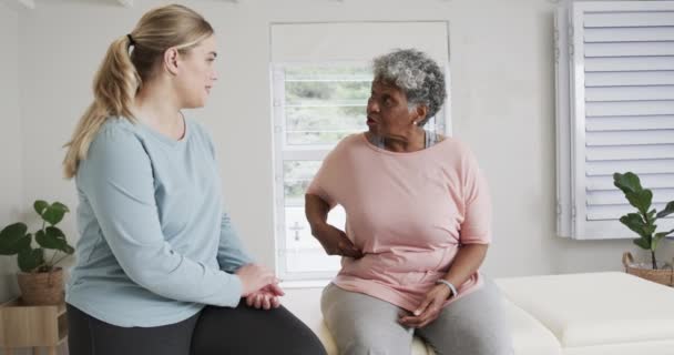 白人女性理疗师谈论老年女性 复制空间 慢动作 老年生活方式 理疗师 医疗保健服务 工作观念 — 图库视频影像