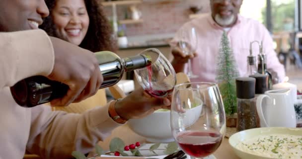 Счастливый Африканский Американский Муж Наливает Вино Жене Старшему Отцу Рождественским — стоковое видео
