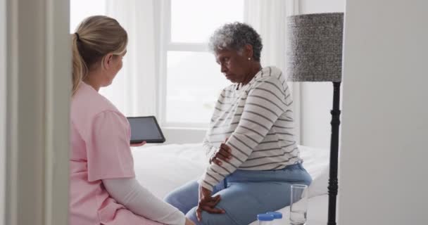 白种人女护士和资深非洲裔美国妇女使用平板 复制空间 慢动作 老年生活方式 医疗保健 工作观念 — 图库视频影像