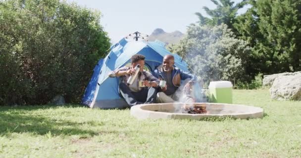 Glücklicher Afrikanisch Amerikanischer Vater Und Erwachsener Sohn Sitzen Draußen Zelt — Stockvideo
