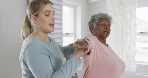 白种人女性理疗师与老年女性一起锻炼 复制空间 慢动作 老年生活方式 理疗师 医疗保健服务 工作观念 — 图库视频影像