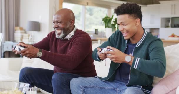 Волнующий Африканский Отец Взрослый Сын Играют Видеоигры Геймпадами Дома Замедленной — стоковое видео