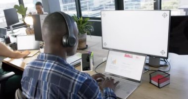 Afrika kökenli Amerikalı iş adamı ofisinde boş ekranlı bilgisayar kullanıyor, yavaş çekim, kopyalama alanı. Günlük iş, ofis, iş, profesyonel konsept, değiştirilmemiş.