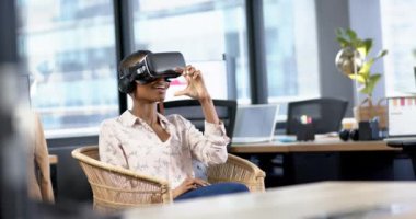 Afrika kökenli Amerikalı iş kadını ofiste video kulaklık kullanıyor, yavaş çekim, kopyalama alanı. Günlük iş, ofis, iş, profesyonel konsept, değiştirilmemiş.