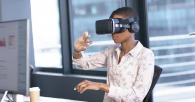 Afrika kökenli Amerikalı iş kadını ofiste video kulaklık kullanıyor, yavaş çekim, kopyalama alanı. Günlük iş, ofis, iş, profesyonel konsept, değiştirilmemiş.