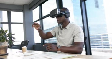 Afrika kökenli Amerikalı iş adamı ofiste video kulaklık kullanıyor, yavaş çekim, kopyalama alanı. Günlük iş, ofis, iş, profesyonel konsept, değiştirilmemiş.