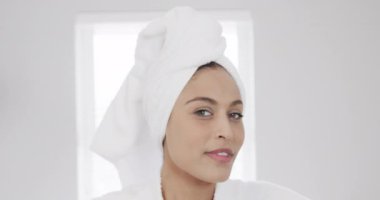 Banyoda kafasında havlu olan mutlu, melez bir kadının portresi, ağır çekimde. Yaşam tarzı, kişisel bakım ve ev hayatı, değişmemiş..