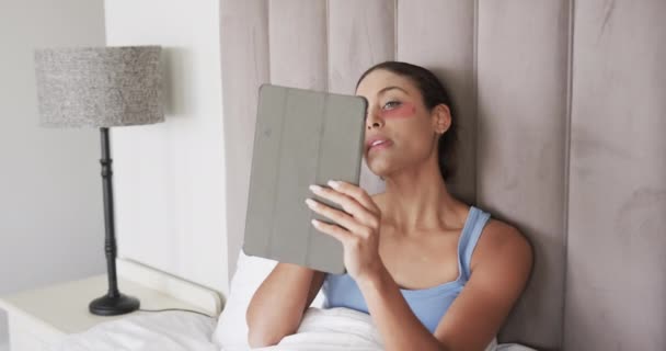Mulher Biracial Com Manchas Debaixo Olho Sentado Cama Usando Tablet — Vídeo de Stock