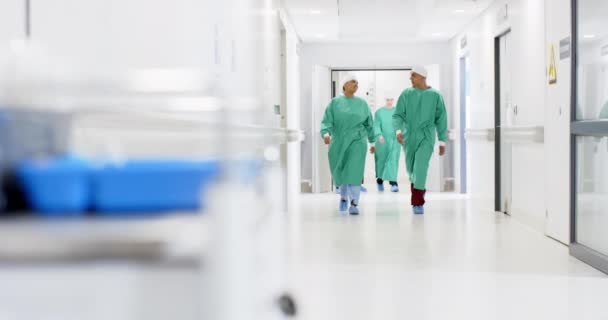 病院の廊下を歩く手術用ガウンを身に着けている多様な男性と女性の外科医 ゆっくりとした動き ヘルスケア チームワーク 病院および仕事 変わらない — ストック動画