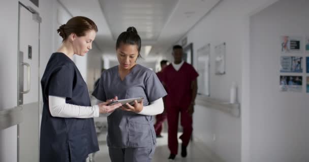 Olika Kvinnliga Läkare Diskuterar Arbete Använder Tablett Korridoren Sjukhuset Slow — Stockvideo