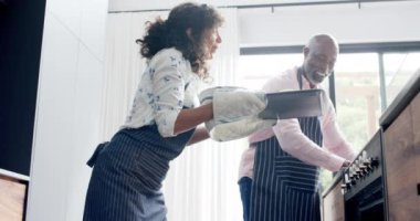 Mutfakta önlük giyip ekmek pişiren mutlu çift, ağır çekimde. Ev hayatı, pişirme ve yaşam tarzı, değişmemiş..