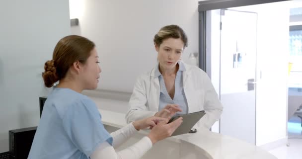 Concentré Divers Médecins Féminins Utilisant Tablette Discuter Sur Réception Hôpital — Video