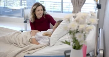 Kafkasyalı anne hasta kızıyla konuşuyor hastane yatağında yatıyor, kopyalama alanı, ağır çekim. Annelik, çocukluk, birliktelik, bakım, sağlık hizmetleri, sağlık ve hastane, değiştirilmemiş.