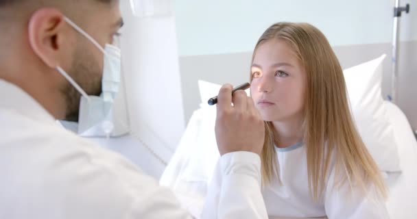 Různorodý Lékař Masce Kontroluje Oči Pacientky Nemocničním Lůžku Tužkou Pomalým — Stock video
