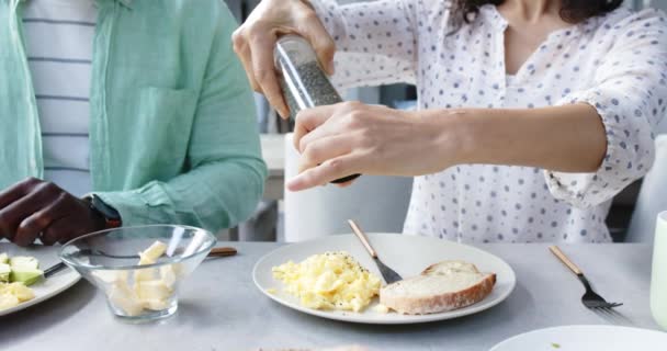 ハッピーなカップル調味料とキッチンでの朝食のためのスクランブルエッグを持っている ゆっくり動き 家庭生活 食べ物 ライフスタイル 変わらない — ストック動画
