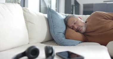 Yorgun, yaşlı, çift ırklı bir adam güneşli oturma odasında uyuyor, fotokopi odası, ağır çekim. Rahatlama, dinlenme, emeklilik, ev hayatı ve yaşlı yaşam tarzı, değişmemiş..