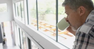 Üst katta kahve içen düşünceli üst sınıf melez adam evine iniyor, fotokopi odası, ağır çekim. Emeklilik, rahatlama, ev hayatı ve yaşlılık hayatı, değişmemiş..