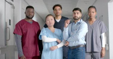 Hastane koridorunda önlük giyen çeşitli erkek ve kadın doktorların portresi, ağır çekimde. Tıp, sağlık, takım çalışması, hastane ve iş, değiştirilmemiş.