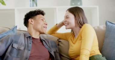 Kanepede oturup evde ağır çekimde konuşan ve gülen mutlu çift. İlişki, birliktelik, yaşam tarzı ve aile hayatı değişmedi..