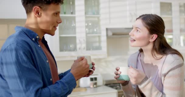 ハッピーな多様なカップルは 自宅でキッチンでコーヒーを飲んで ゆっくりと動いています 関係性 トータル性 ライフスタイル 家庭生活 変わらない — ストック動画