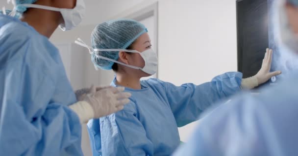 不同的女外科医生在手术室里看X光扫描 动作缓慢 医疗保健 团队合作 医院和工作 — 图库视频影像